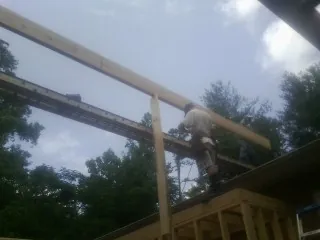 Carpenter setting a ridge beam over a new addition frame — Ice Dam Removal by Roofing Brothers in Plainview